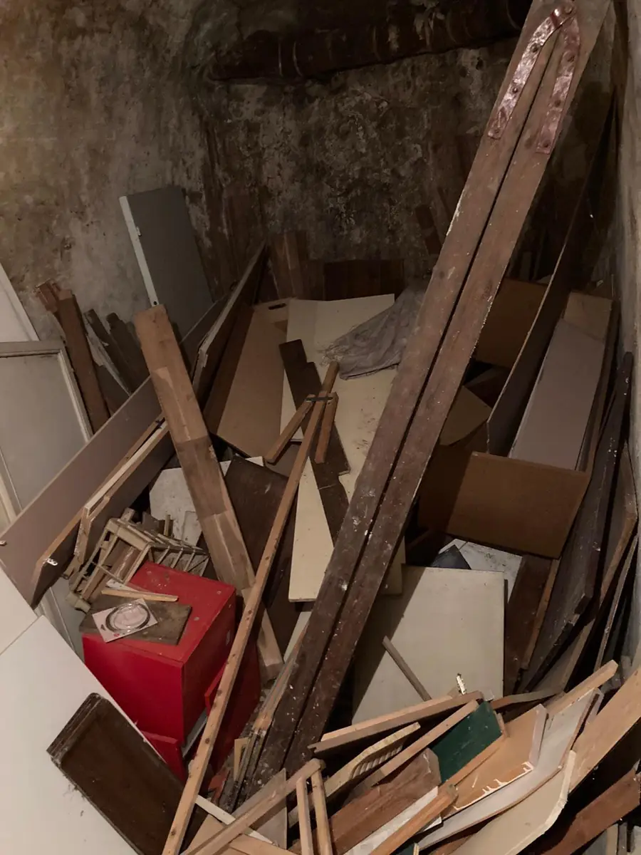 Box saturé de bois et mobilier — débarras de cave à Paris
